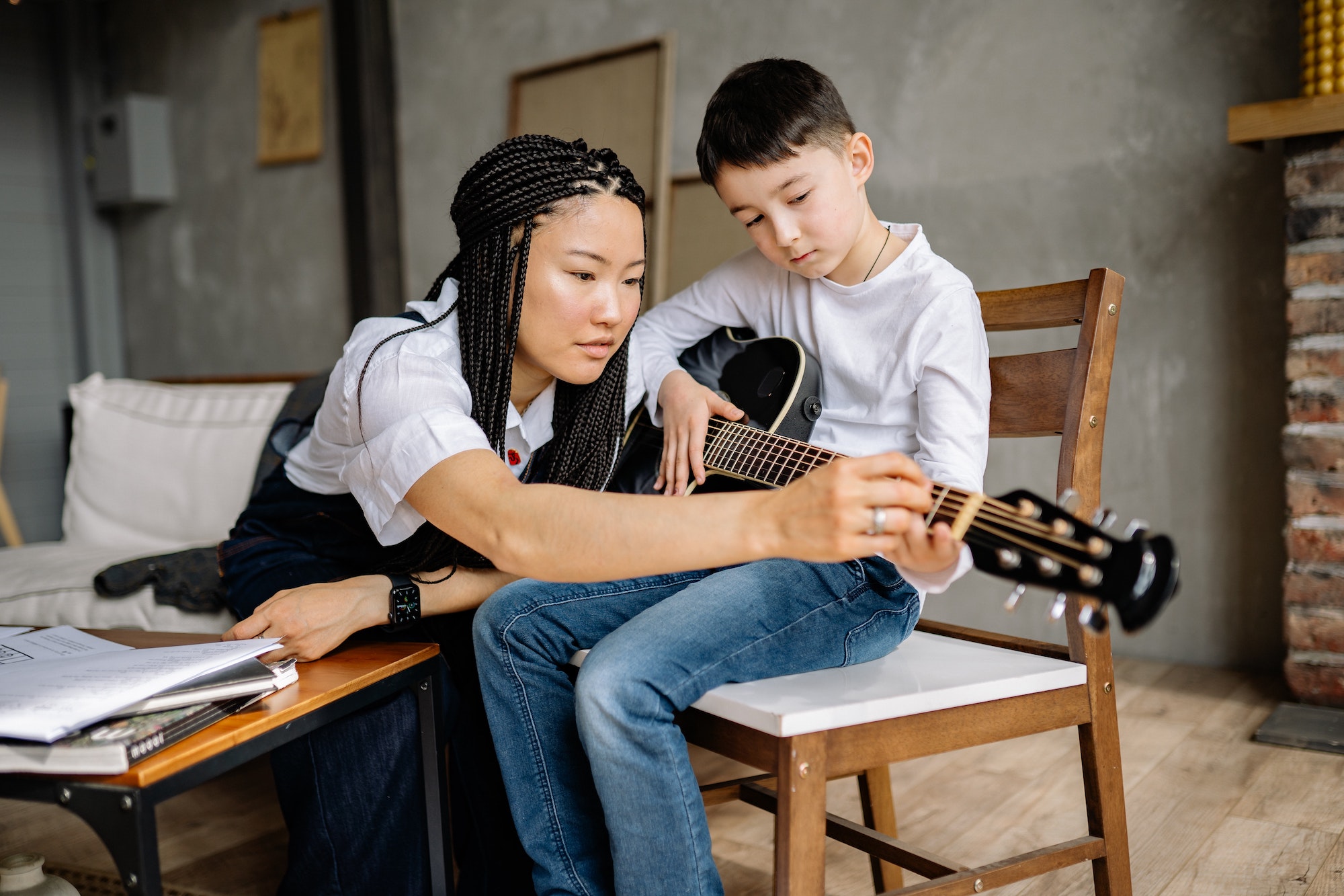 Small boy learning to play the guitar