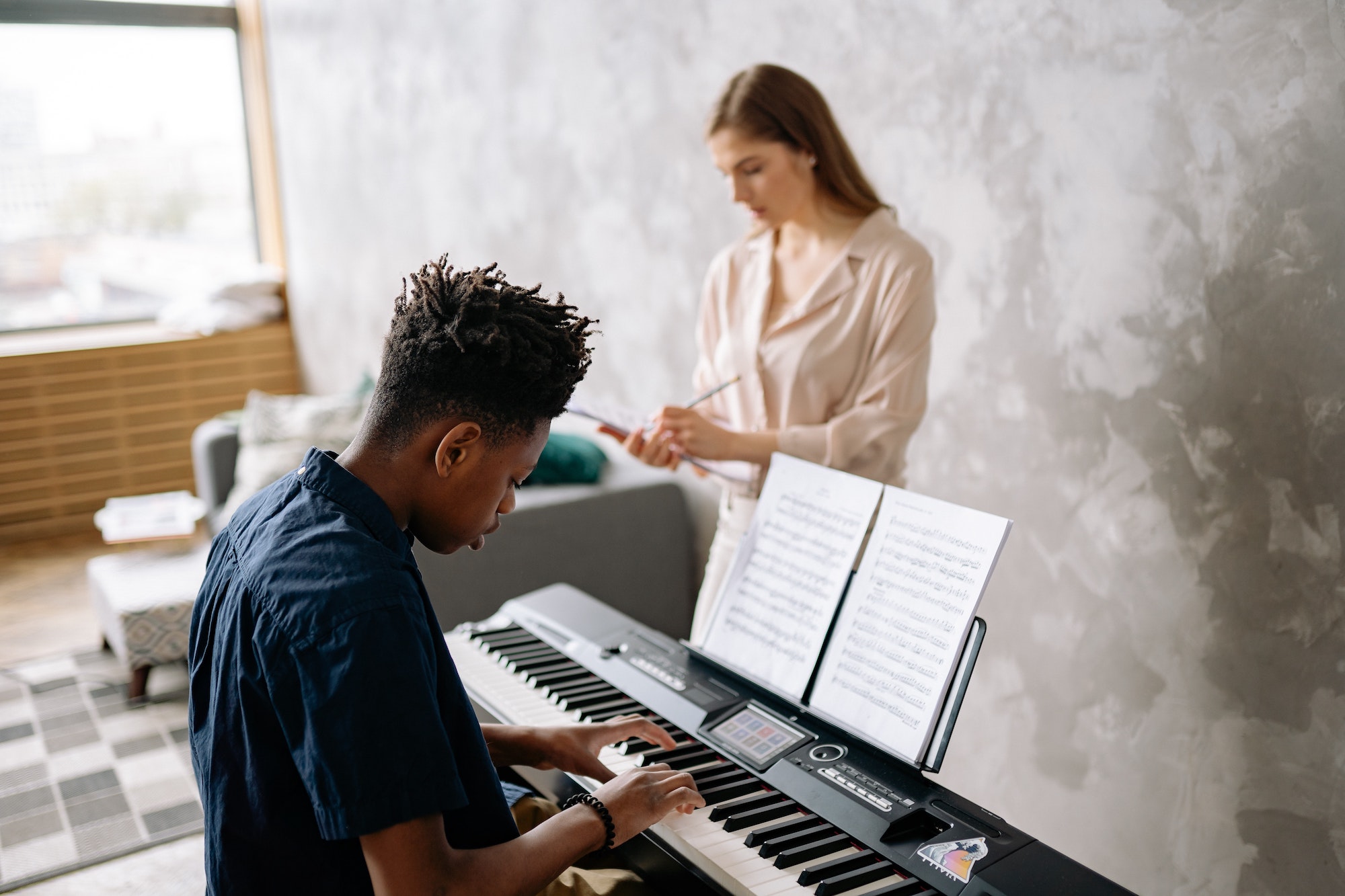 Middle school boy learning to play the piano with teacher